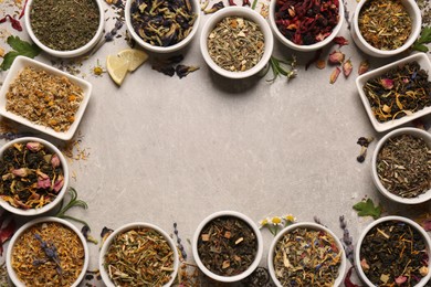 Photo of Frame of different dry teas on light grey table, flat lay. Space for text