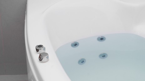 Photo of Hot tub with clean water in bathroom