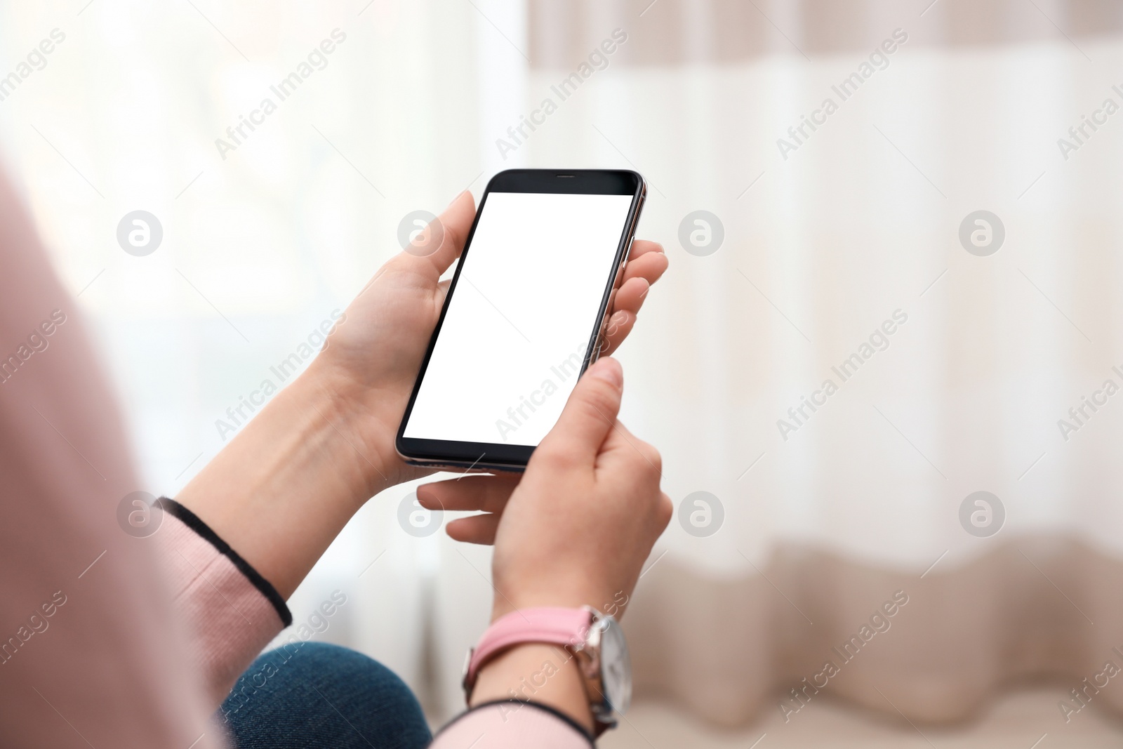 Photo of Woman holding smartphone with blank screen indoors, closeup of hands. Space for text