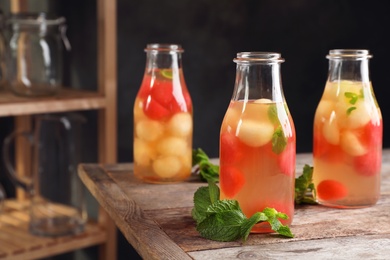 Bottles with tasty melon and watermelon ball drink on table