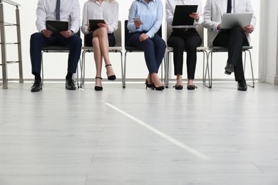 People waiting for job interview in office hall, closeup