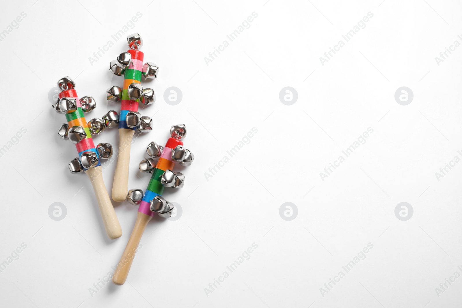 Photo of Wooden shakers with bells on white background, top view. Montessori musical toy