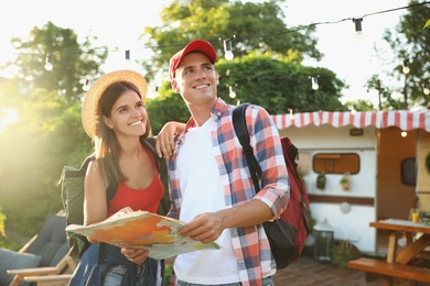 Young travelers with backpacks and map planning trip outdoors