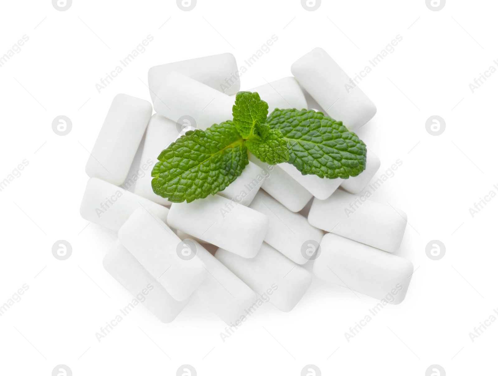 Photo of Heap of chewing gum pieces and mint on white background, top view