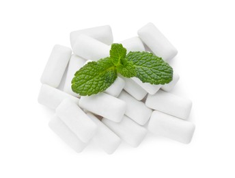 Photo of Heap of chewing gum pieces and mint on white background, top view