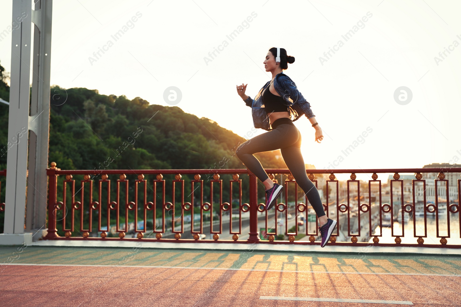 Photo of Beautiful sporty young woman running in city