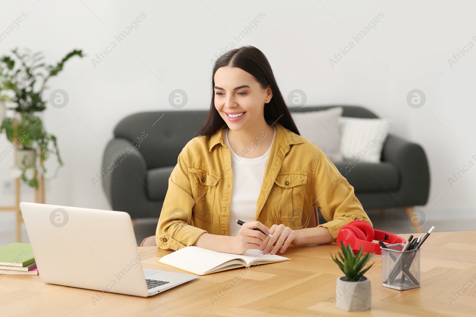 Photo of Woman studying on laptop at home. Online translation course