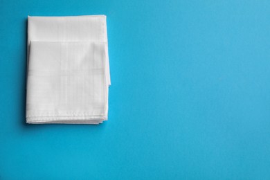 Stylish white handkerchiefs on light blue background, flat lay. Space for text