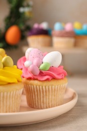 Photo of Tasty decorated Easter cupcakes on wooden table, closeup