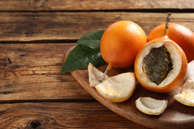 Delicious ripe granadillas on wooden table, closeup