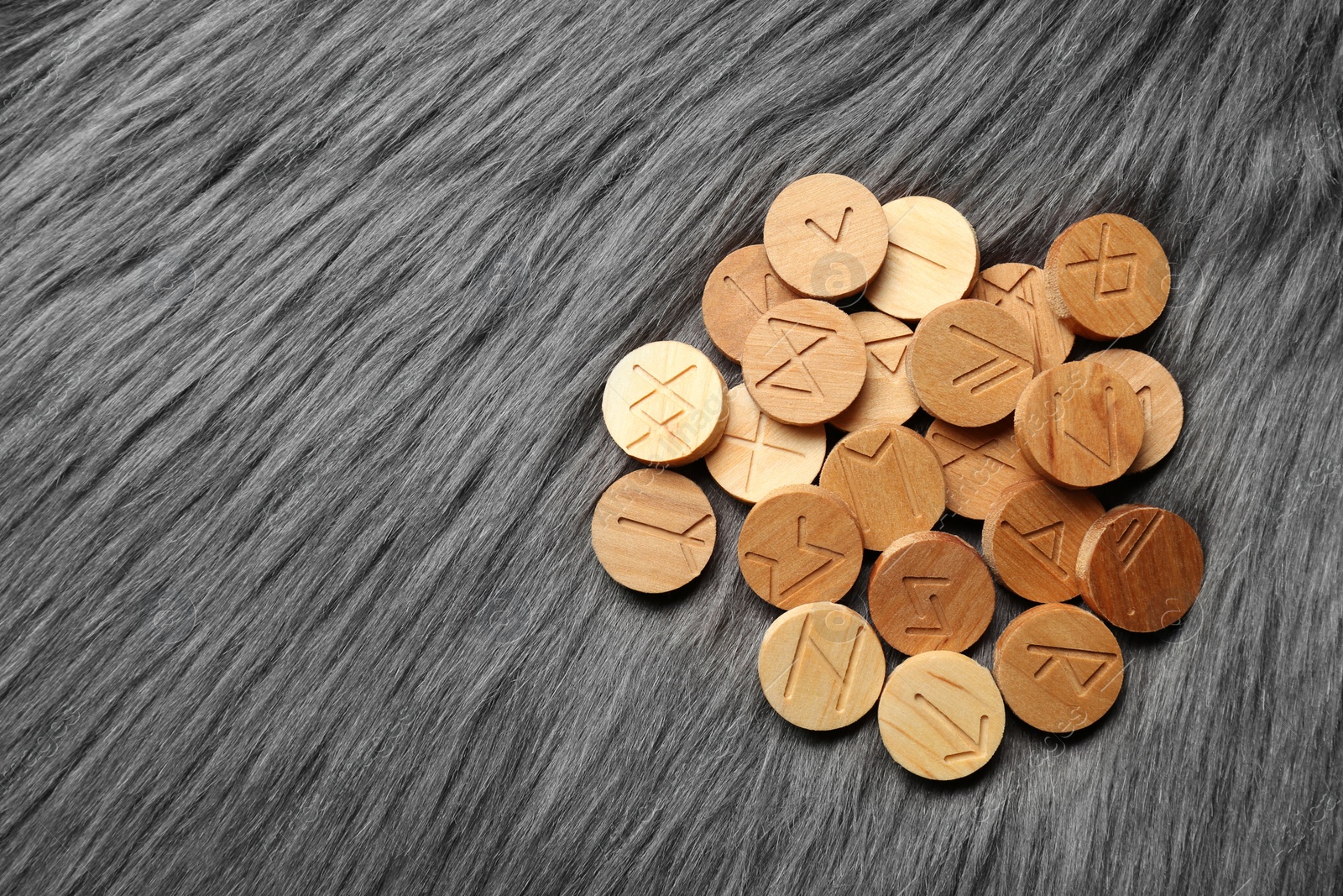 Photo of Pile of wooden runes on grey faux fur, flat lay. Space for text