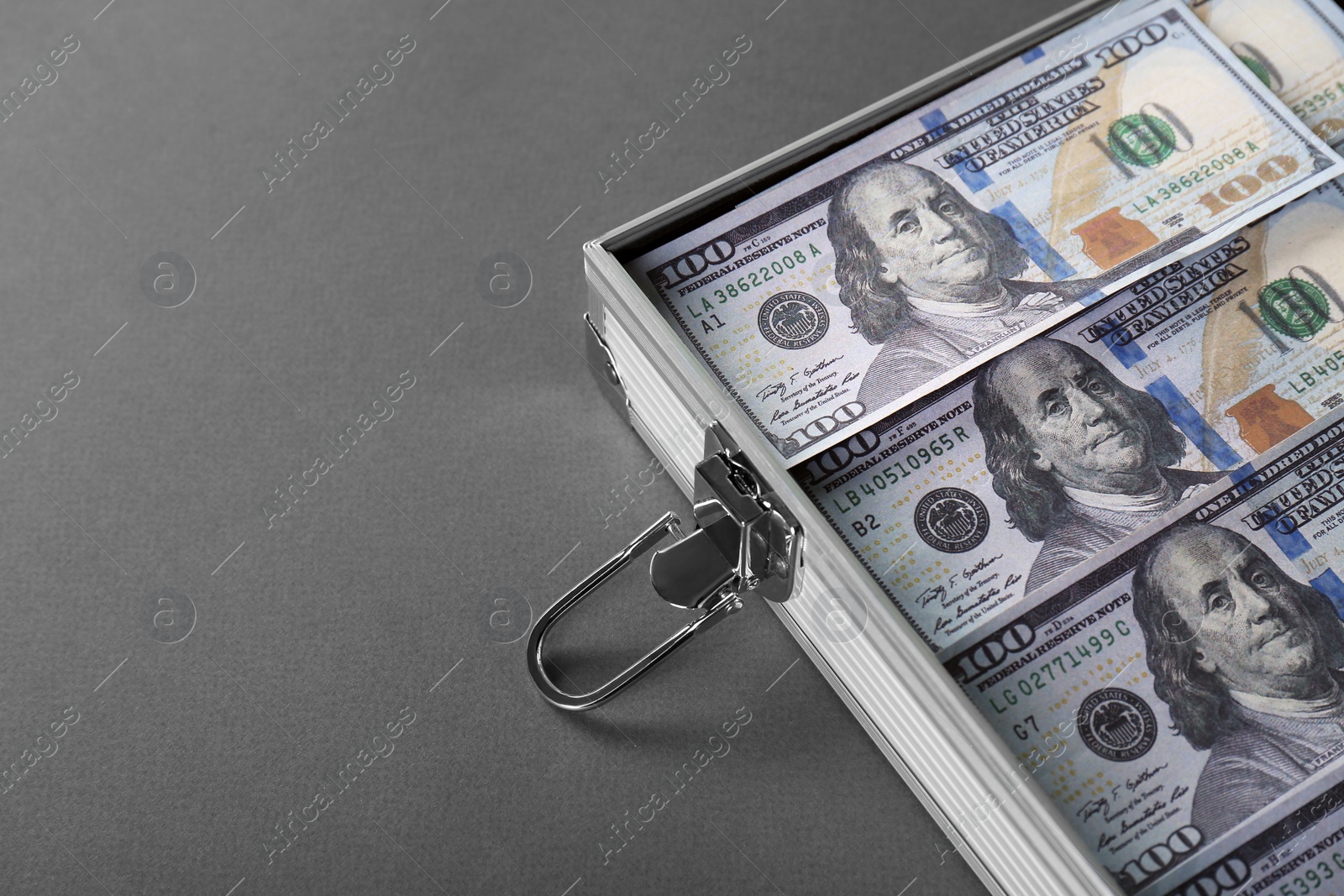 Photo of Briefcase with banknotes on grey table, closeup. Space for text