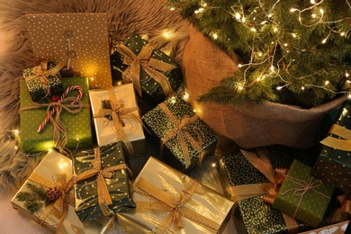 Many different gifts under Christmas tree indoors, above view