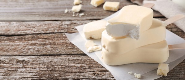 Image of Delicious glazed ice cream bars on wooden table, space for text. Banner design