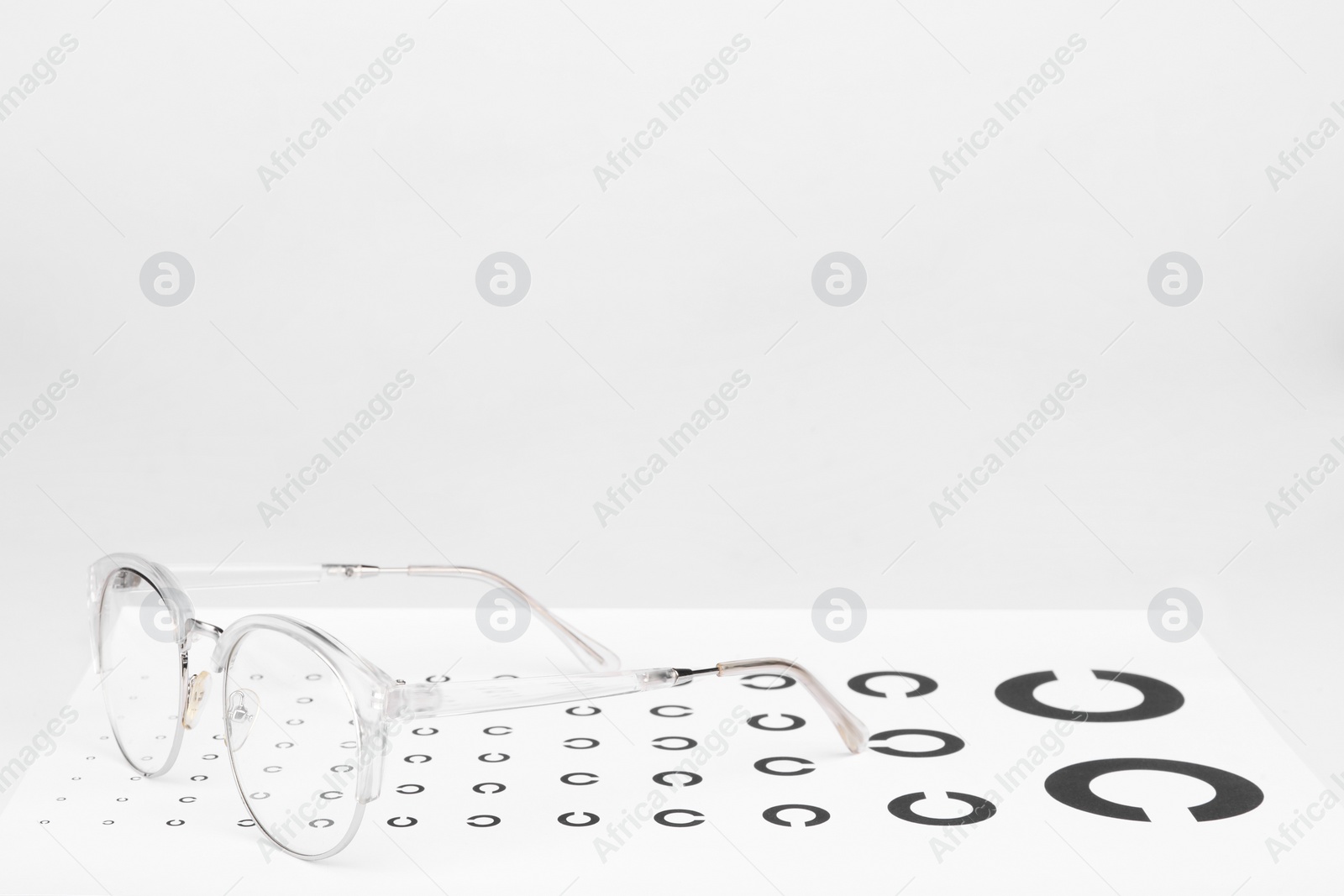 Photo of Glasses and vision test chart isolated on white