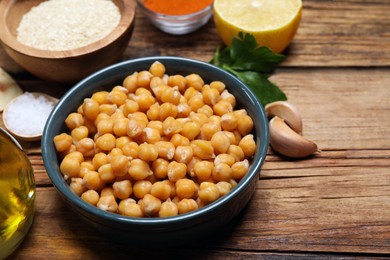 Photo of Delicious chickpeas on wooden table, closeup. Hummus ingredient