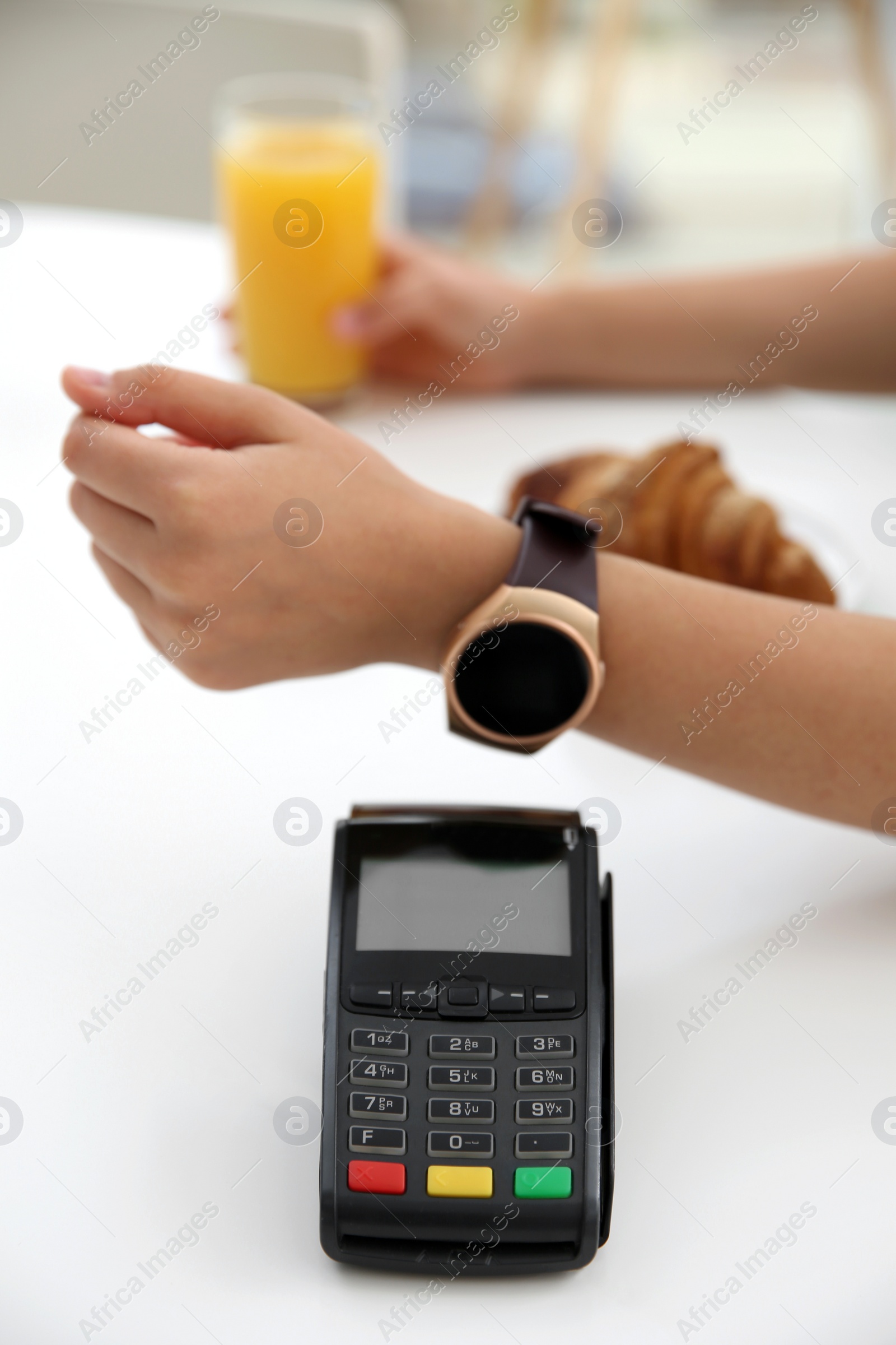 Photo of Woman using smart watch for contactless payment via terminal in cafe, closeup