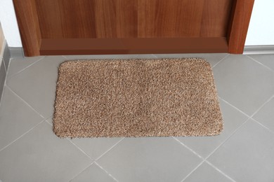 Clean door mat on floor near entrance, above view