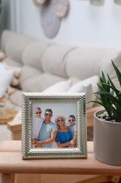 Photo of Framed family photo on wooden table in living room
