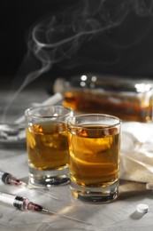 Photo of Alcohol and drug addiction. Whiskey in glasses, syringes and pills on grey background