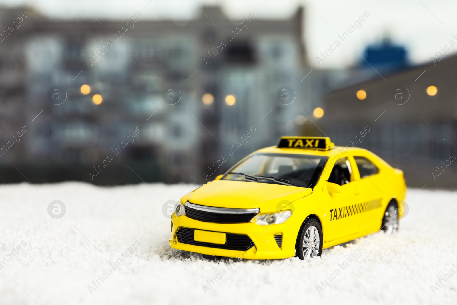 Photo of Yellow taxi car model on snow outdoors