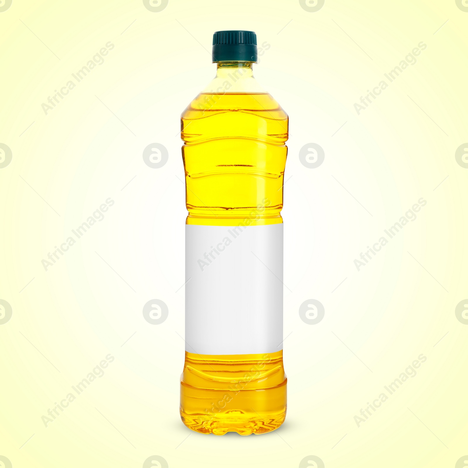 Image of Cooking oil in plastic bottle with empty label on light yellow background. Mockup for design