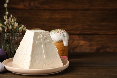 Photo of Traditional cottage cheese Easter paskha on wooden table, space for text