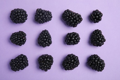 Flat lay composition with ripe blackberries on color background