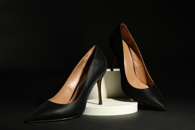 Pair of elegant high heel shoes on black background