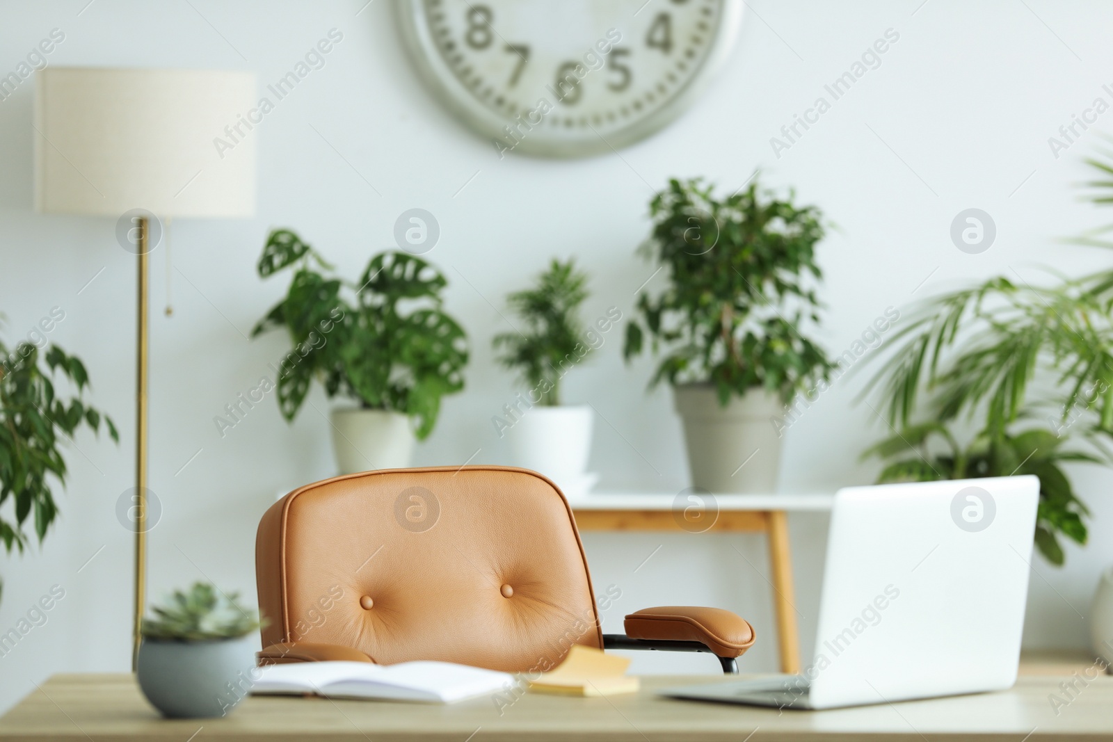 Photo of Comfortable workplace with modern laptop on wooden table in room. Interior design