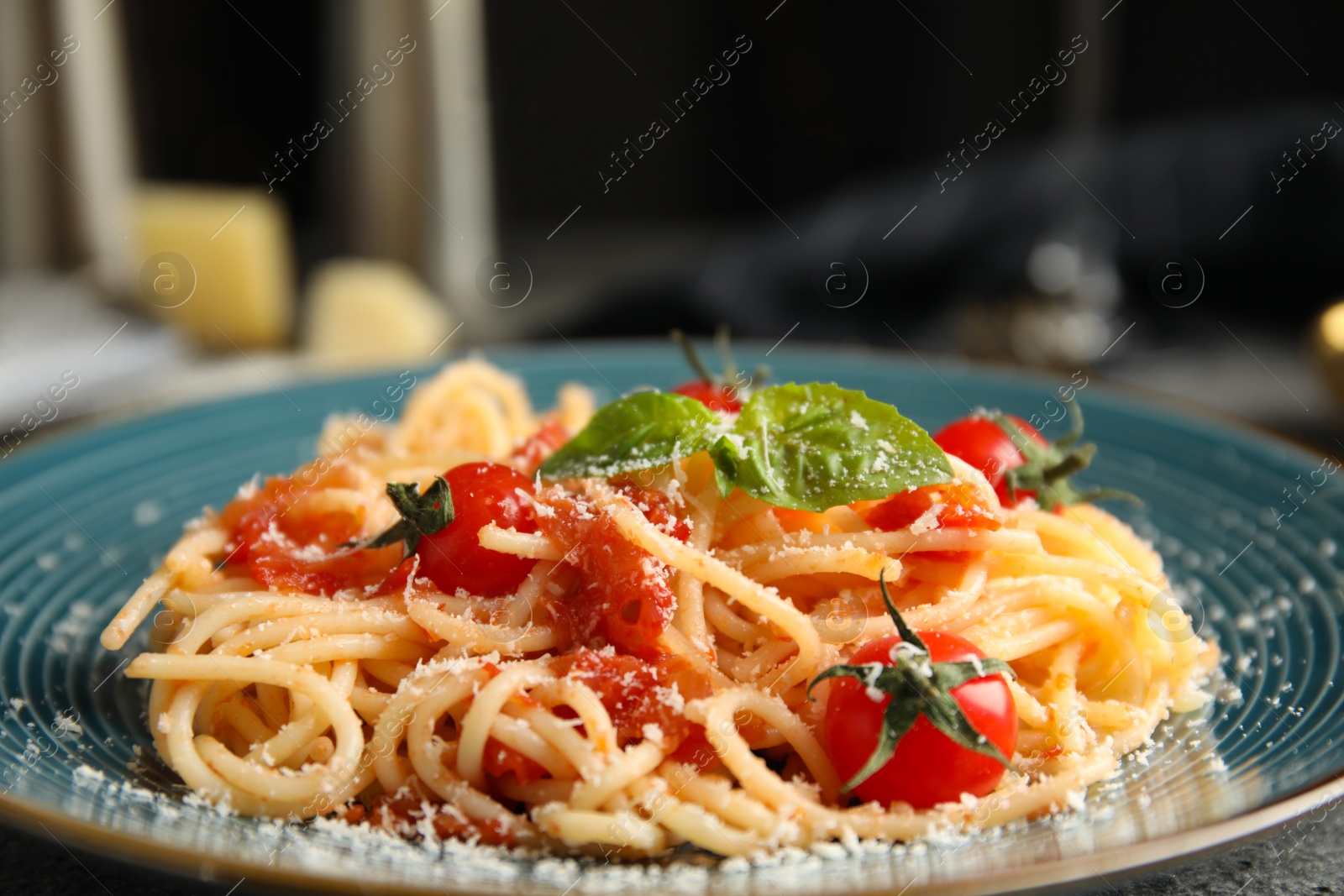 Photo of Tasty pasta with basil, tomatoes and cheese on table, closeup