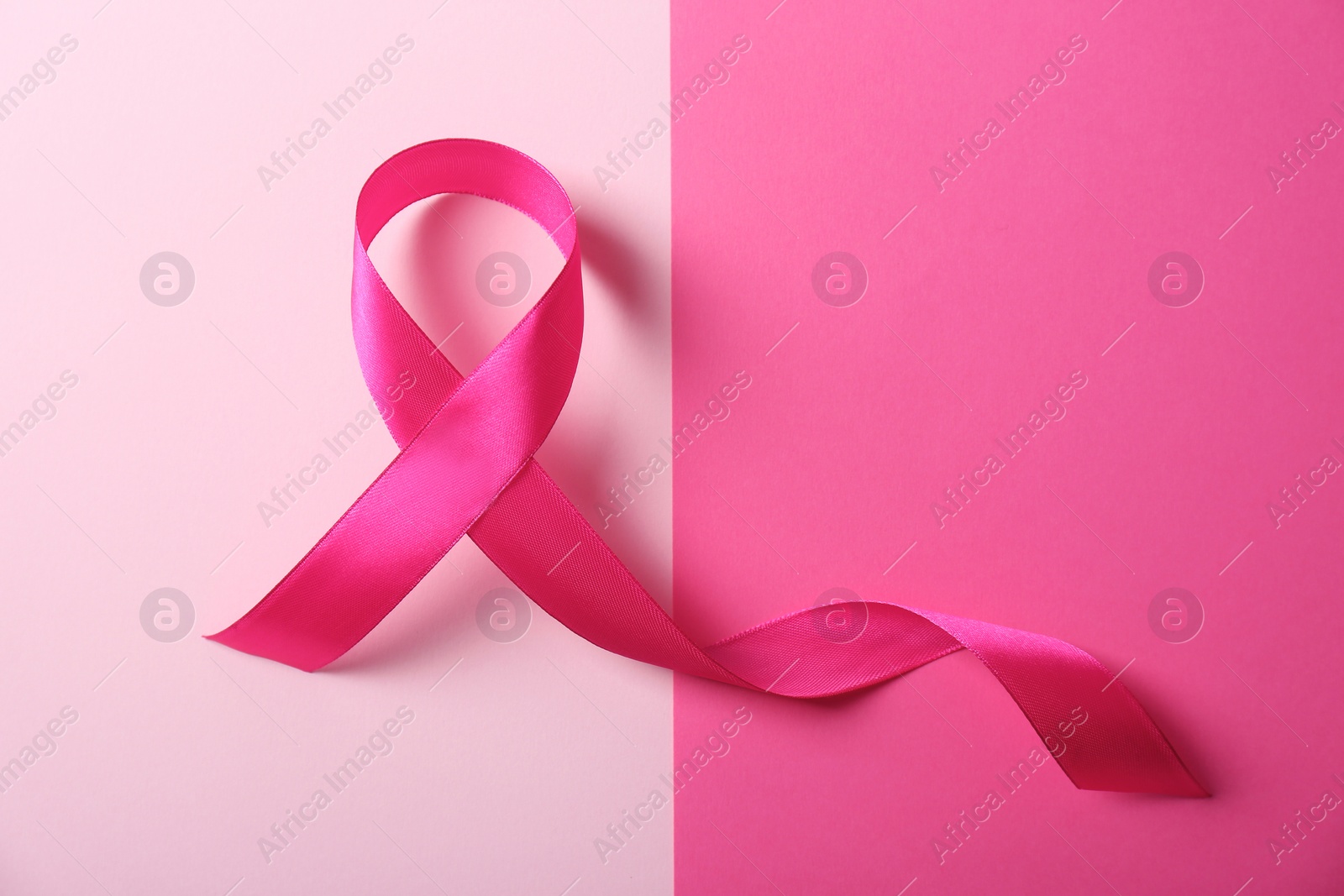 Photo of Pink ribbon and space for text on color background. Breast cancer awareness concept