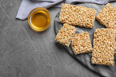 Photo of Delicious rice crispy treats on grey table, flat lay