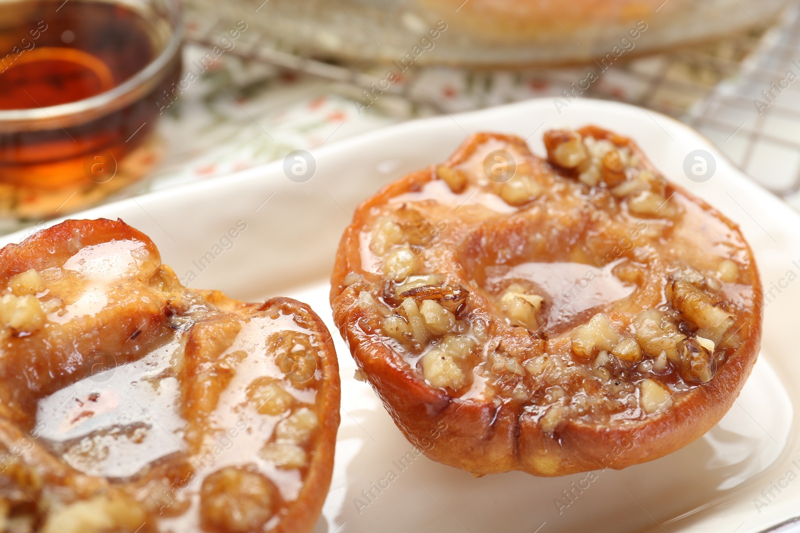 Photo of Delicious quinces baked with honey and walnuts on table, closeup