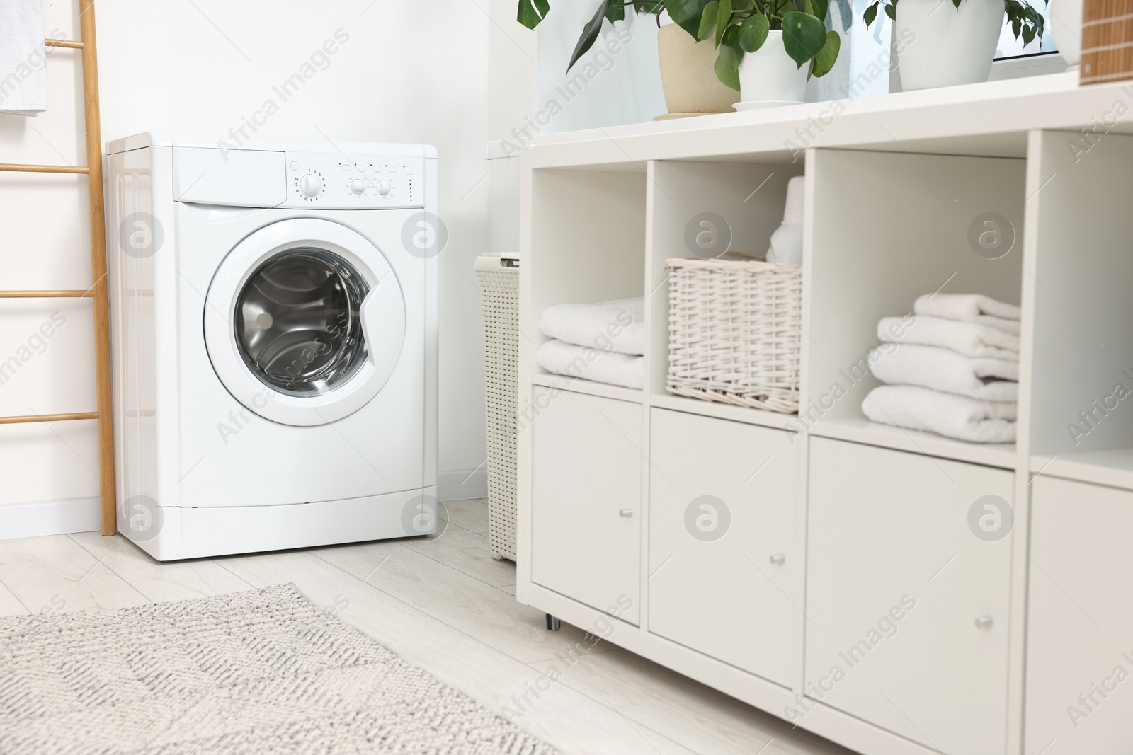 Photo of Laundry room interior with washing machine and furniture