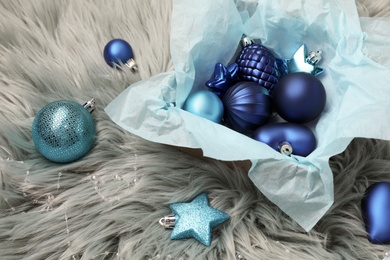 Beautiful Christmas baubles and box on grey faux fur