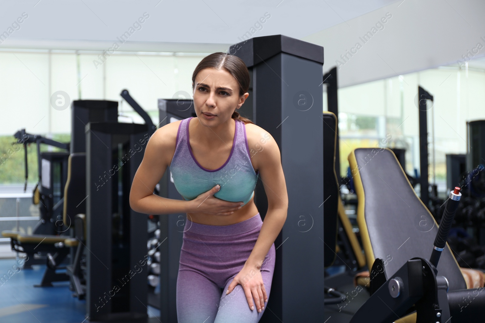 Photo of Young woman having heart attack in gym