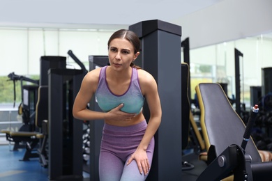 Young woman having heart attack in gym