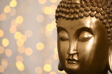 Buddha statue against blurred lights, closeup. Space for text