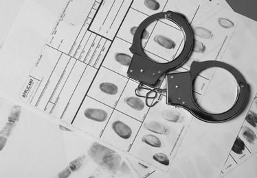 Photo of Police handcuffs and criminal fingerprints card, top view