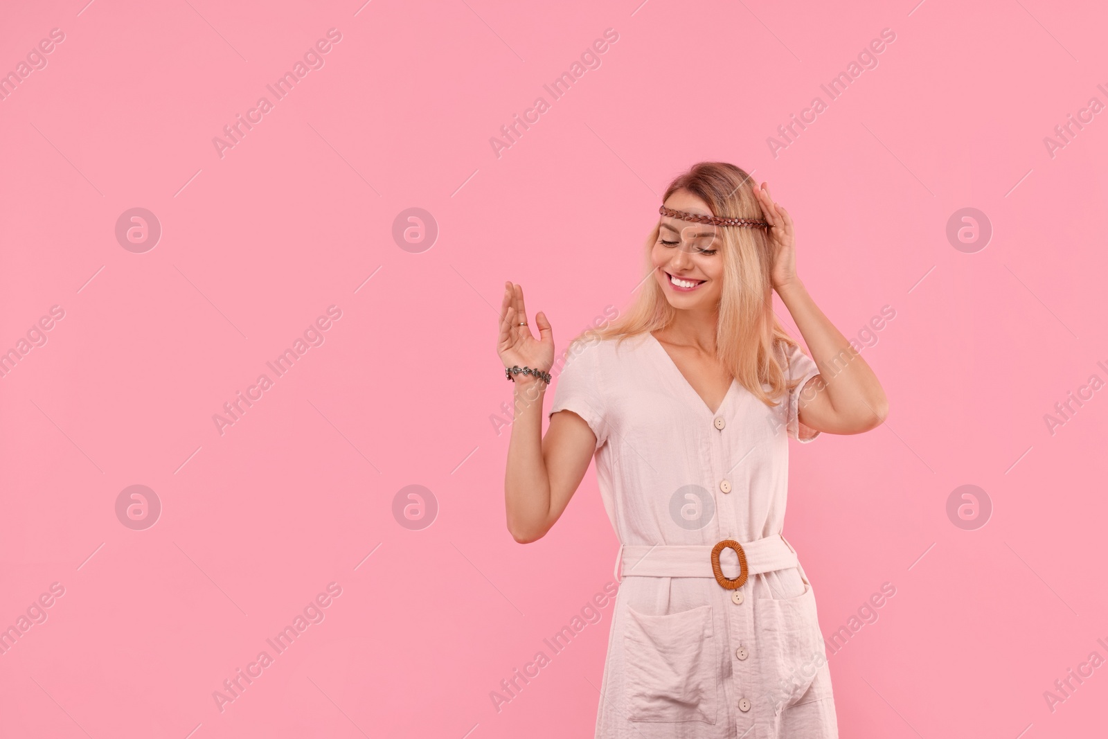 Photo of Portrait of happy hippie woman on pink background. Space for text