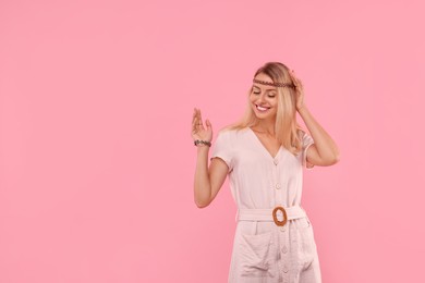 Portrait of happy hippie woman on pink background. Space for text