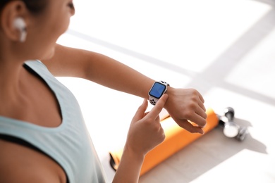 Photo of Woman checking fitness tracker in gym, closeup