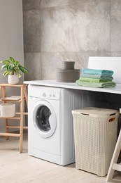 Stylish laundry room with modern washing machine. Interior design