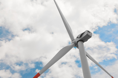 Modern wind turbine against cloudy sky, closeup. Alternative energy source