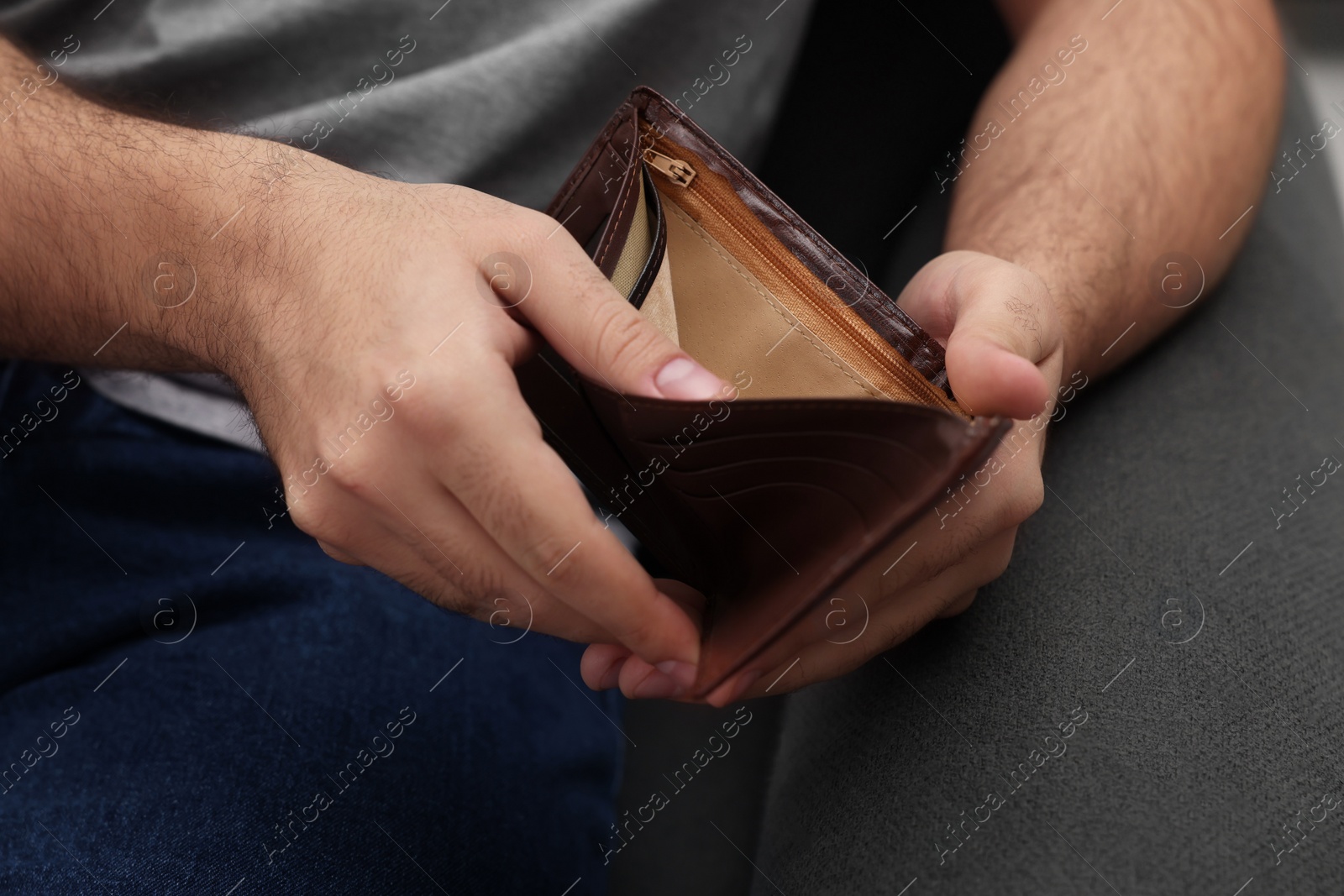 Photo of Man with empty wallet on sofa, closeup