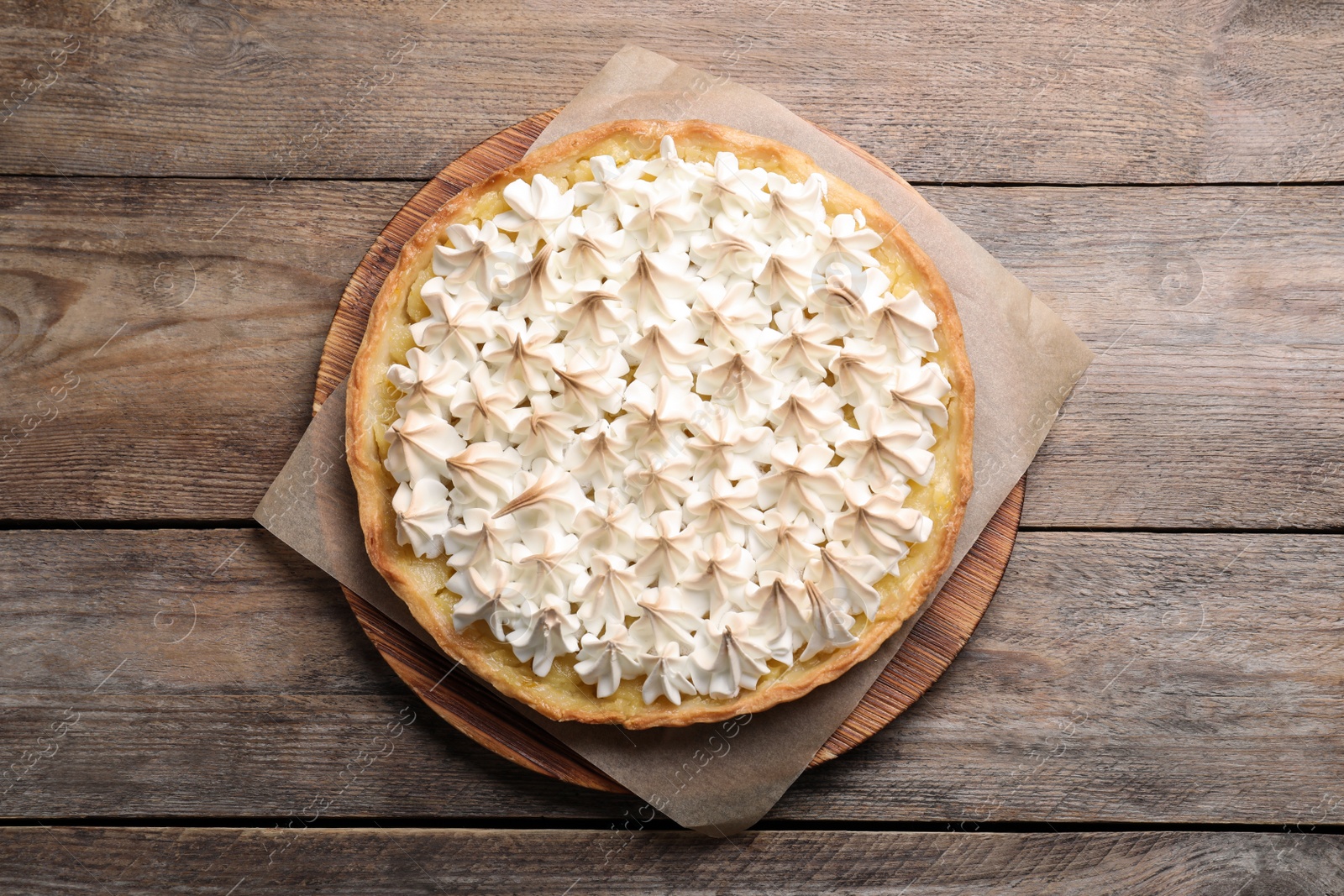 Photo of Delicious lemon meringue pie on wooden table, top view