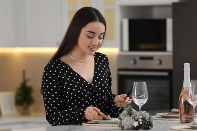 Photo of Christmas mood. Smiling woman serving table in kitchen