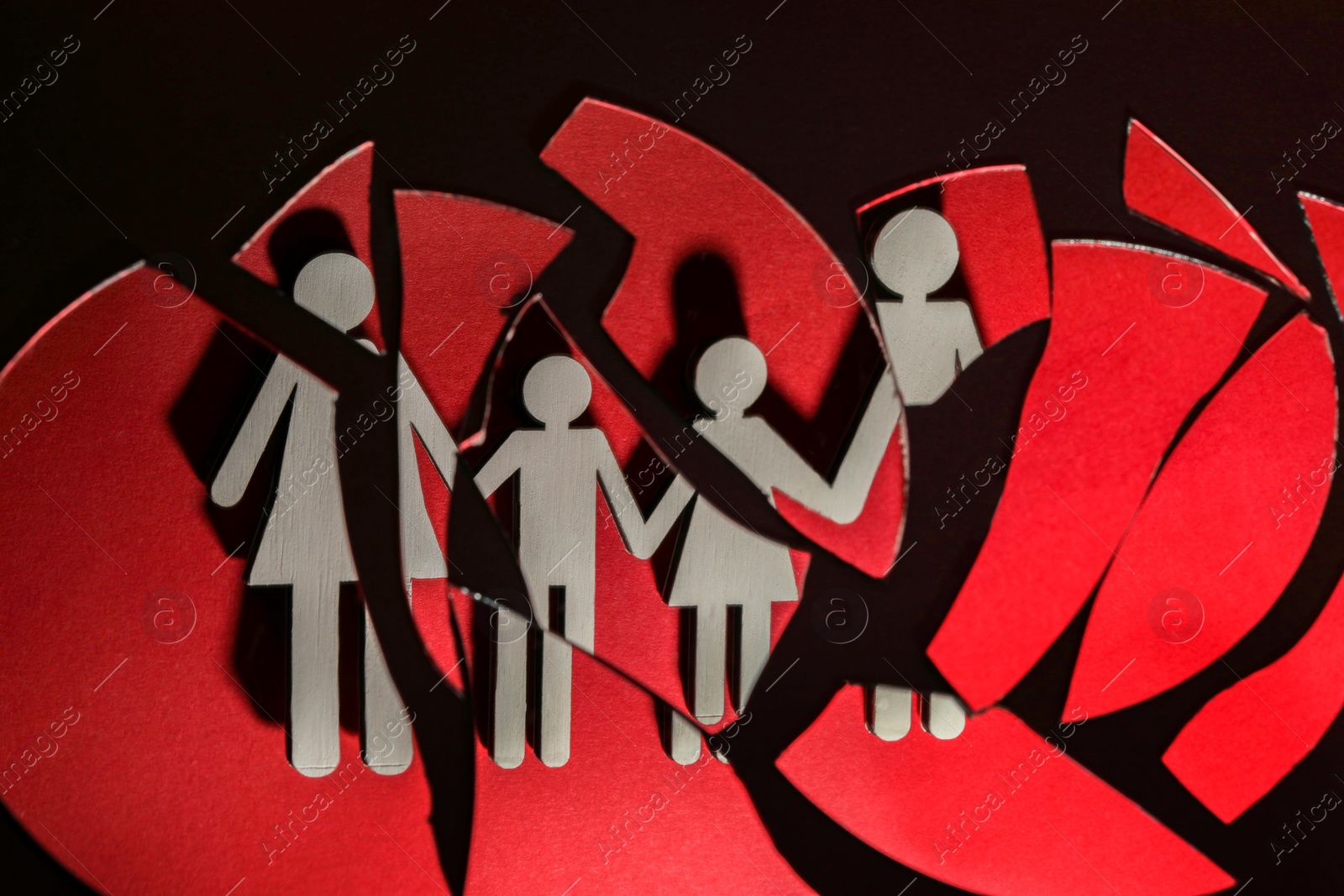 Photo of Human figures reflected in broken mirror on black background. Divorce concept