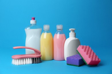 Cleaning supplies and tools on light blue background